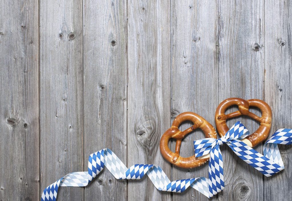Bavarian pretzels with ribbon on wooden board as a background for Oktoberfest