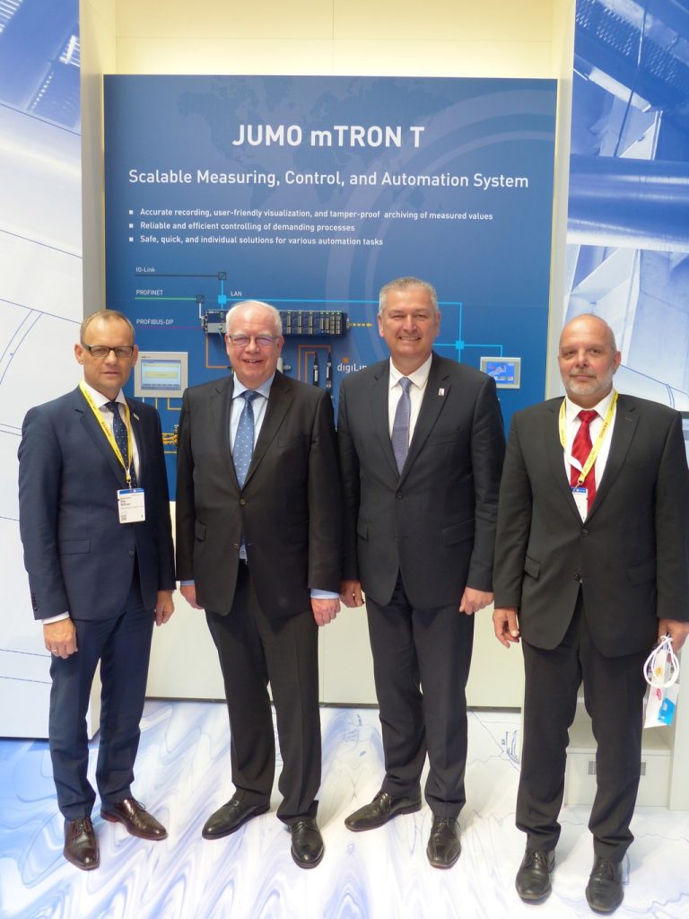 Landrat Bernd Woide (zweiter von rechts), Bürgermeister Dag Wehner (links) und Regionalmanager Christoph Burkard (rechts) haben sich von Bernhard Juchheim (zweiter von links) den JUMO-Stand auf der Hannover Messe präsentieren lassen.